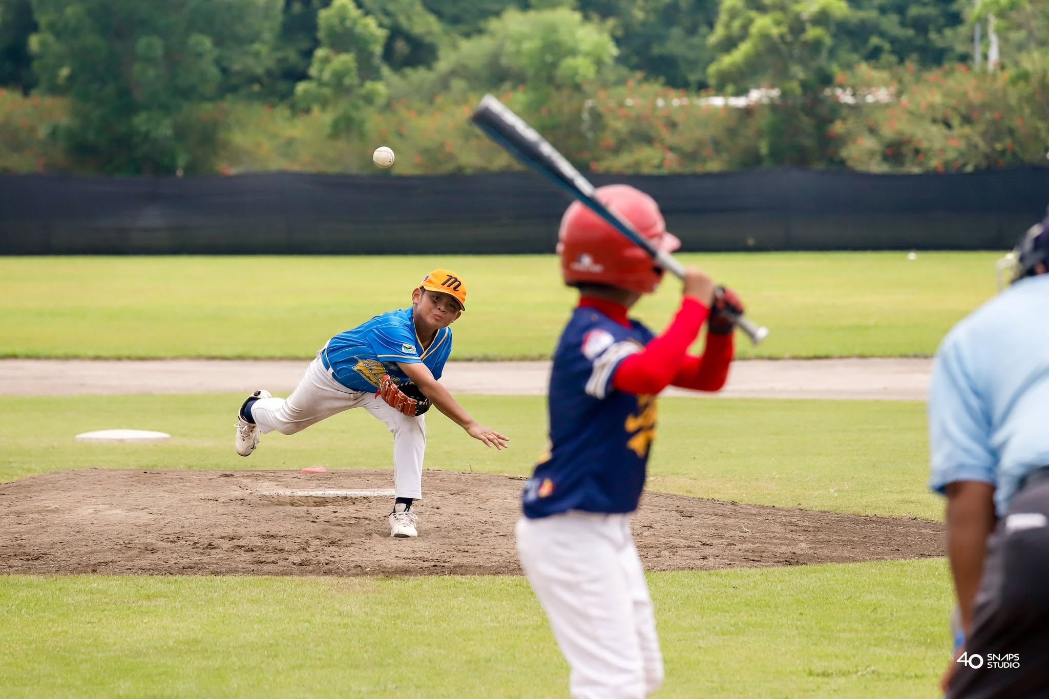Young baseball pitcher delivering a pitch